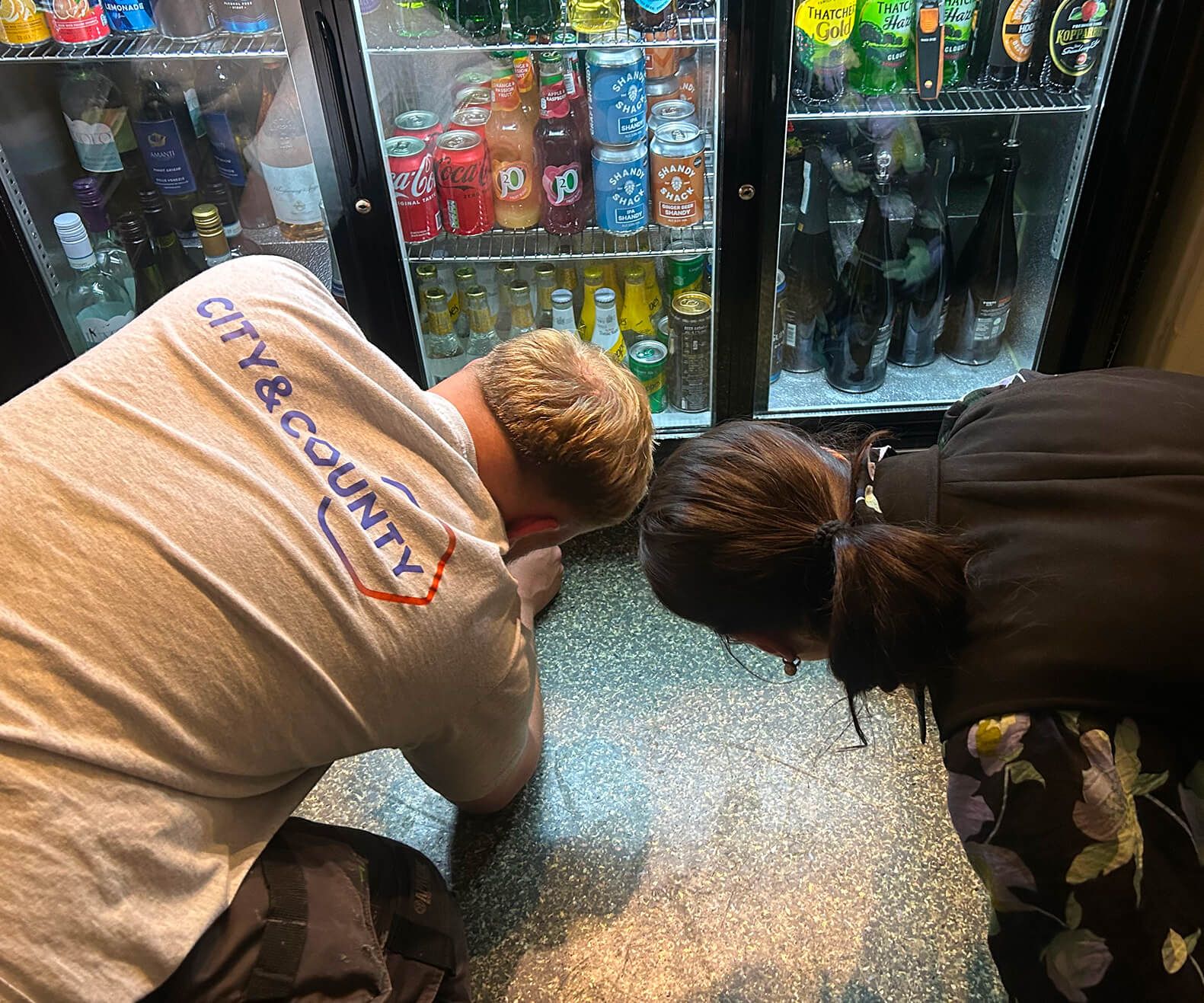 A man servicing a drink fridge