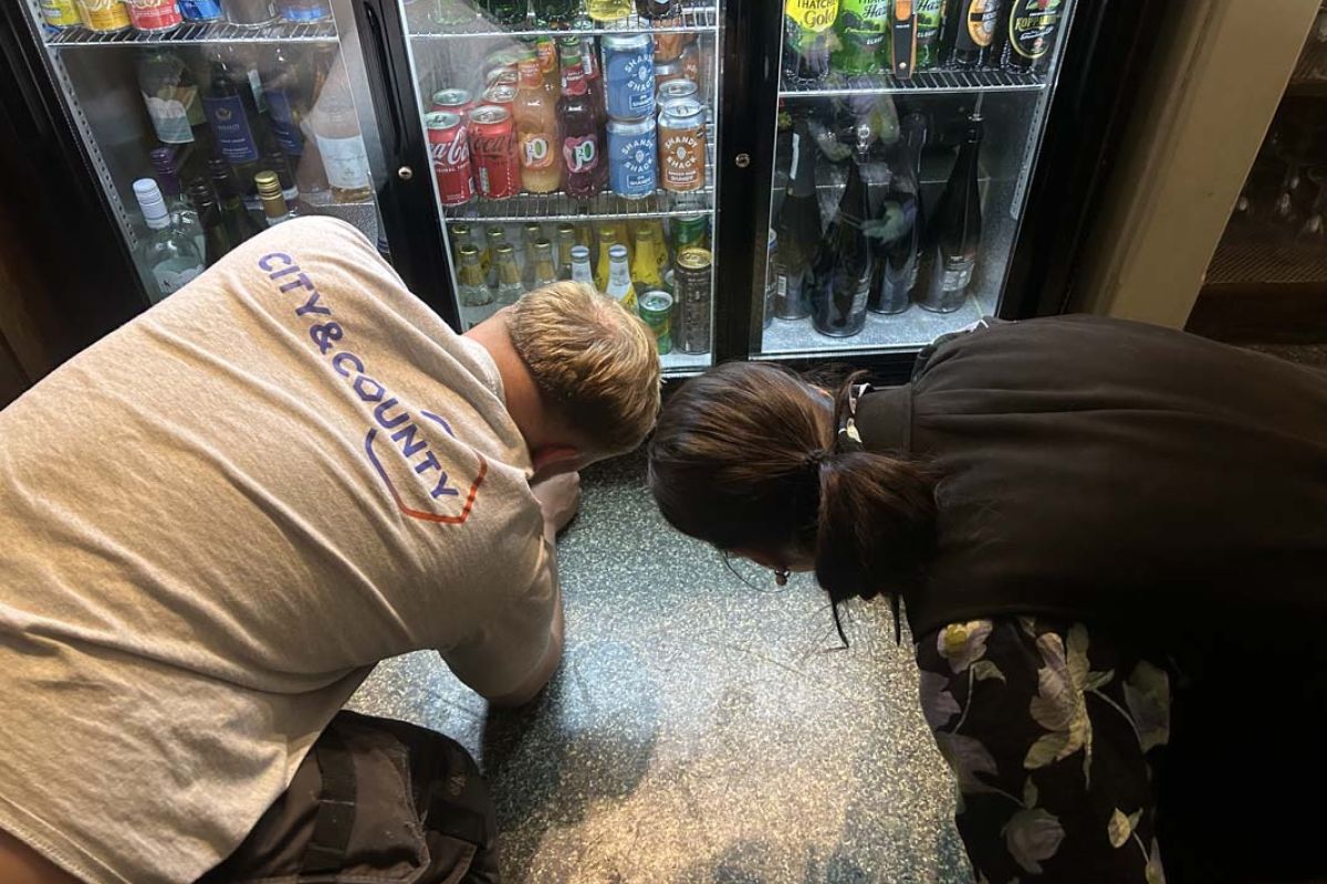 Staff repairing a drink fridge